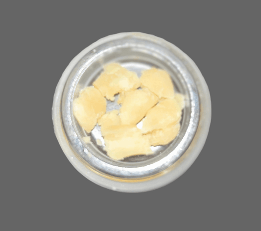 Close-up of 1 gram THCa crumble from I Am Hemp Inc, showing golden, textured cannabis concentrate with high 67.6% potency.