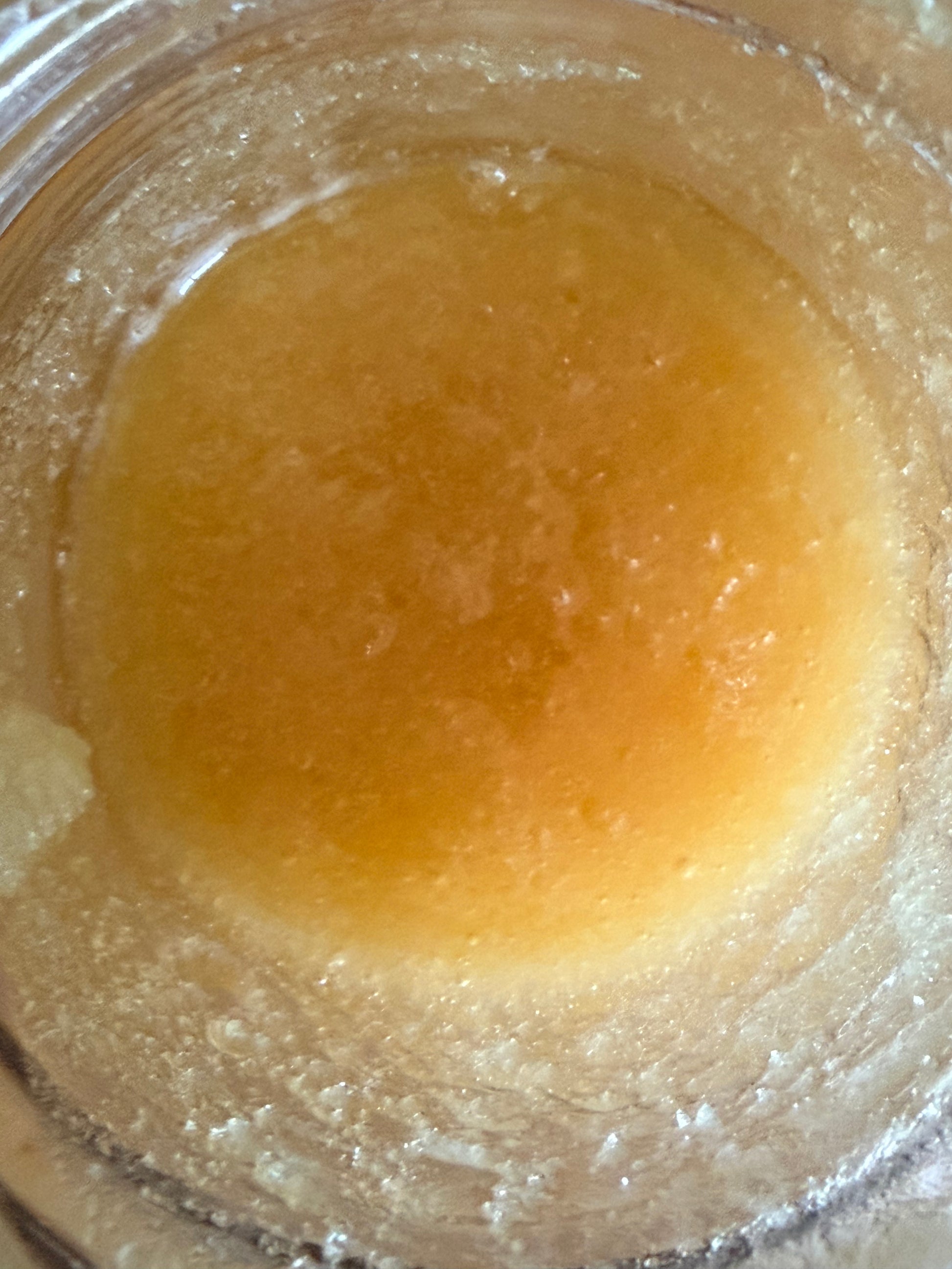 Close-up of 1 gram I Am Hemp Inc THCa Live Resin concentrate with 94.1% potency, showcasing its amber, viscous texture.