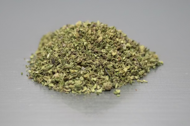 Mixed strain THCa Shake from I Am Hemp Inc, showcasing a close-up of the flower with vibrant green buds and trichomes.